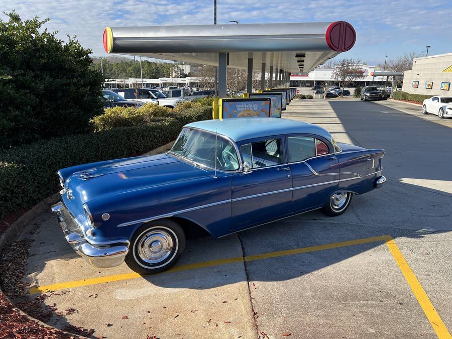Blue 1955 Oldsmobile Super Rocket 88 parked on a street